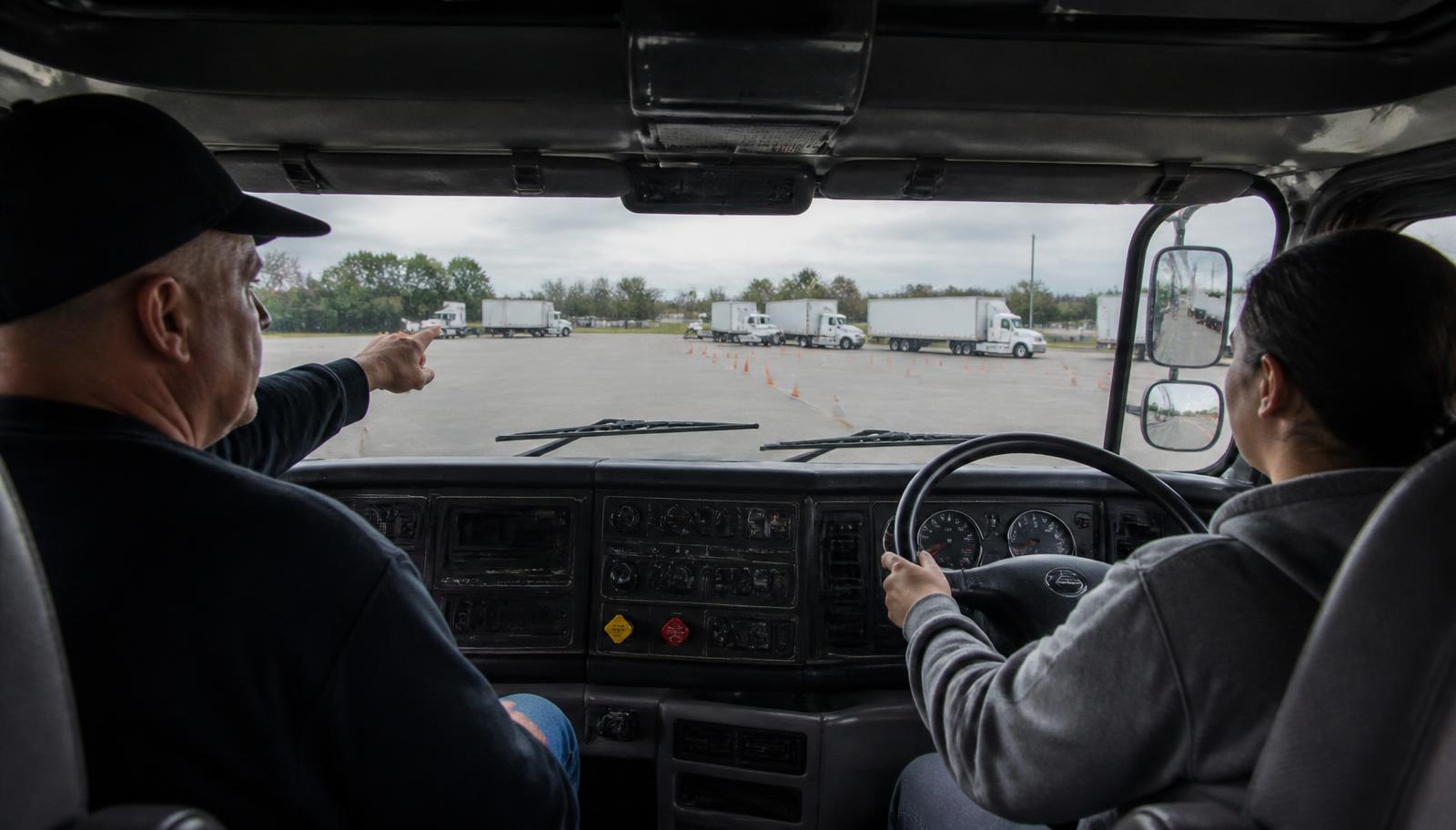 CDL student receiving behind-the-wheel training with an instructor